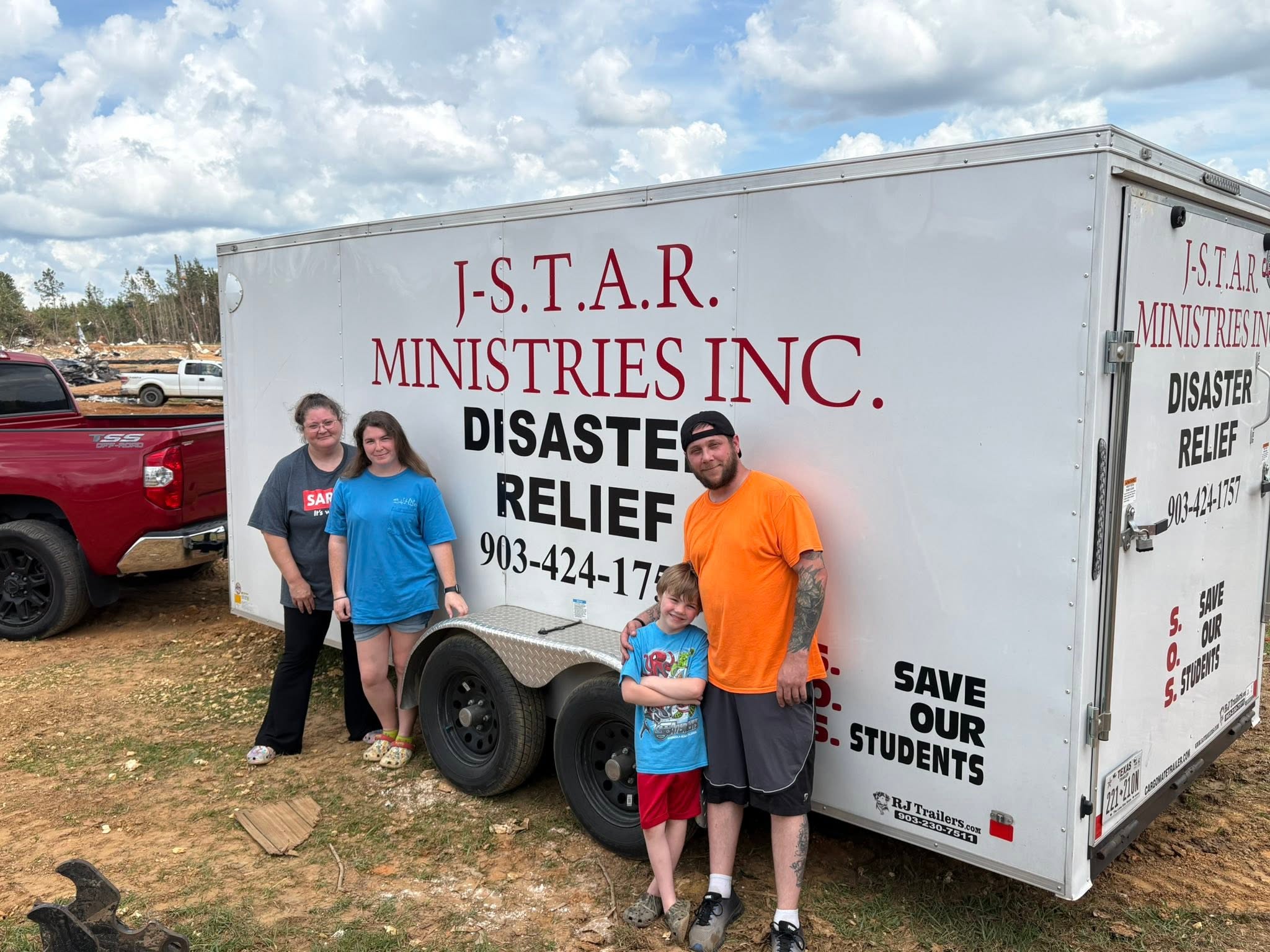 A family beside the J-STAR disaster relief trailer during the Bogue Chitto delivery.