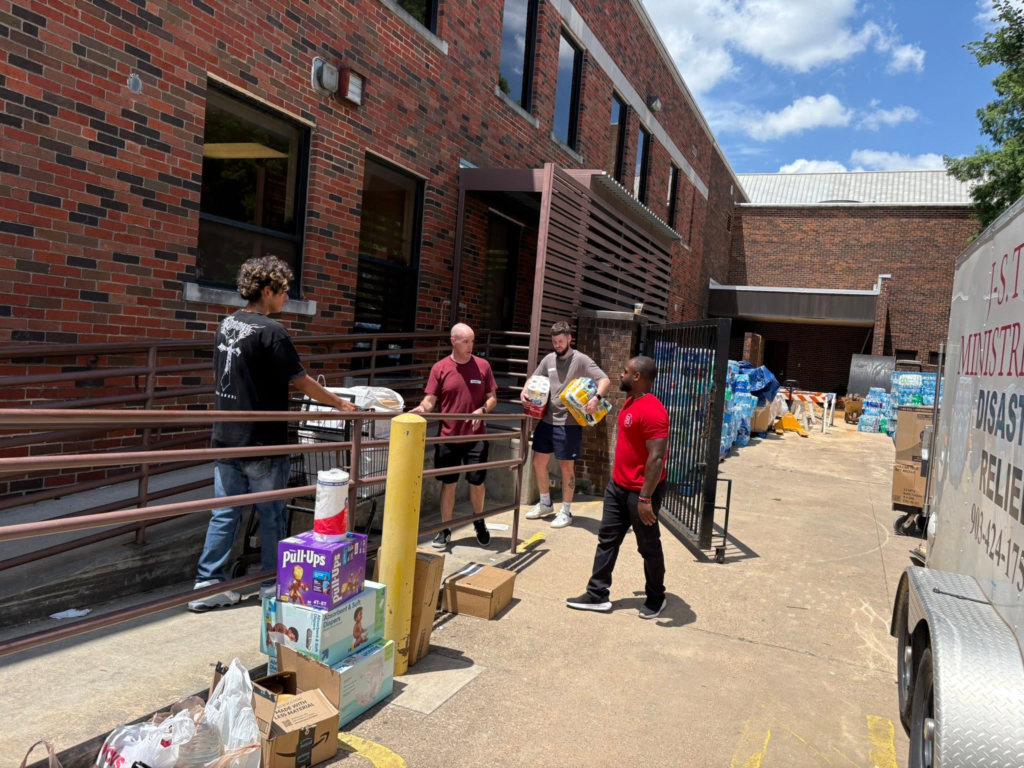 Patrick and volunteers unload diapers, water, and household supplies at Mission Oak Cliff.
