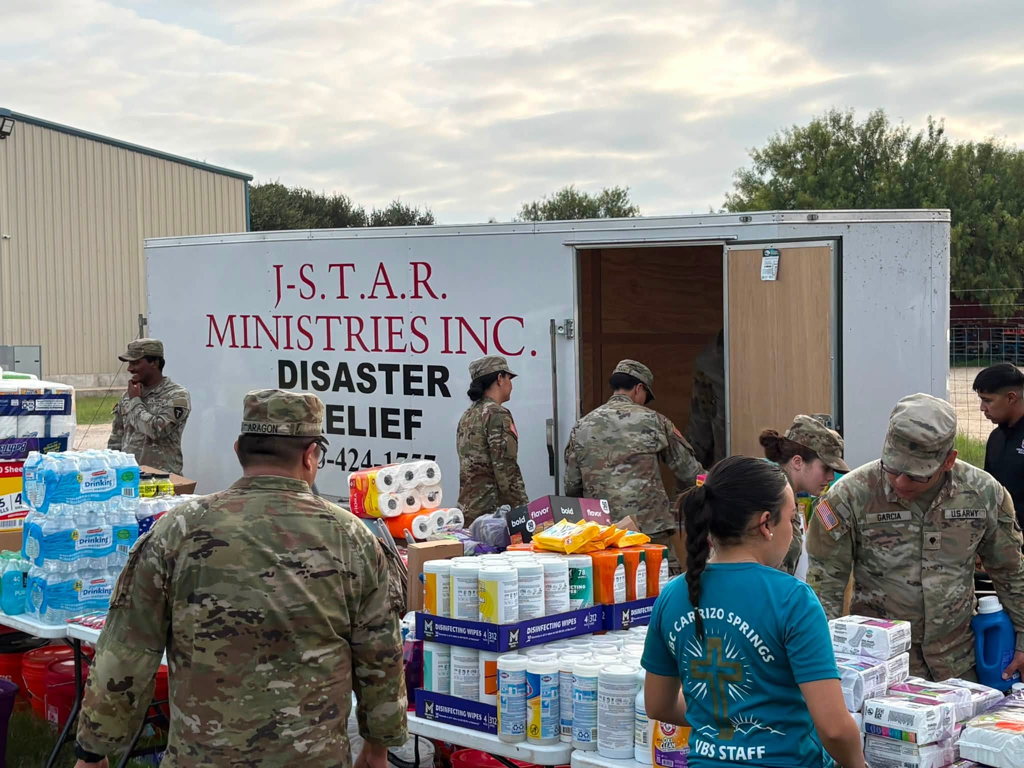 Volunteers unload water, paper goods, and cleaning supplies from the J-STAR trailer in Crystal City.