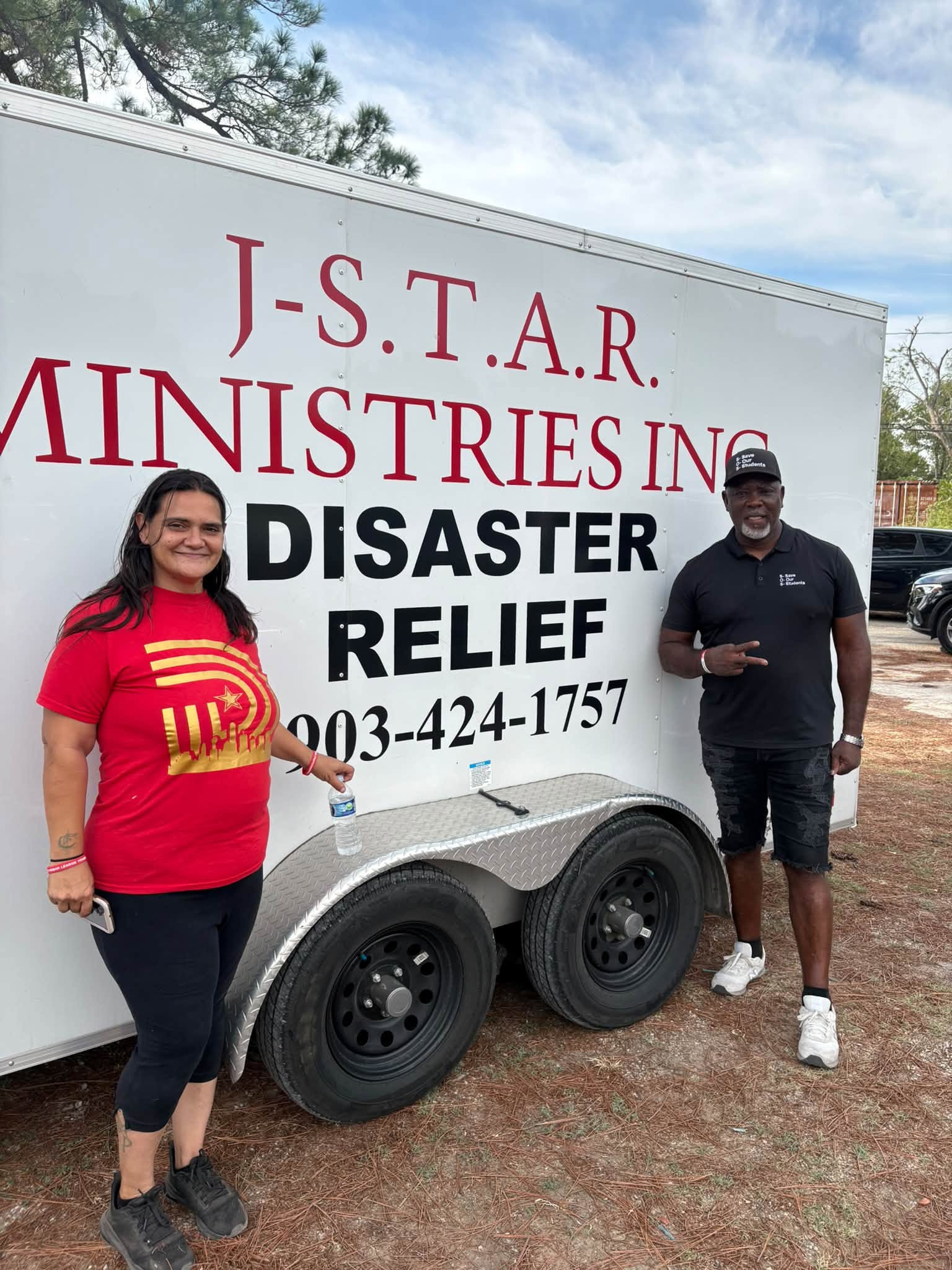 Patrick Johnson and a community partner beside the J-STAR relief trailer in Sand Branch.