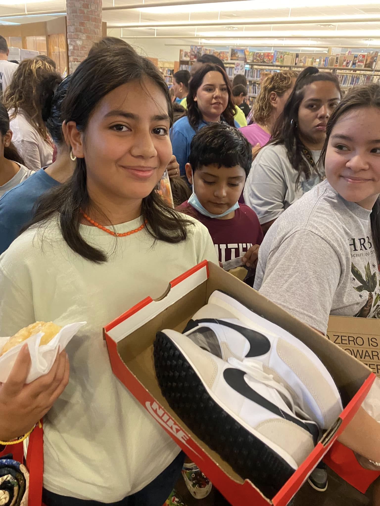 A child receives donated shoes at the August 2022 El Progreso Memorial Library outreach in Uvalde.